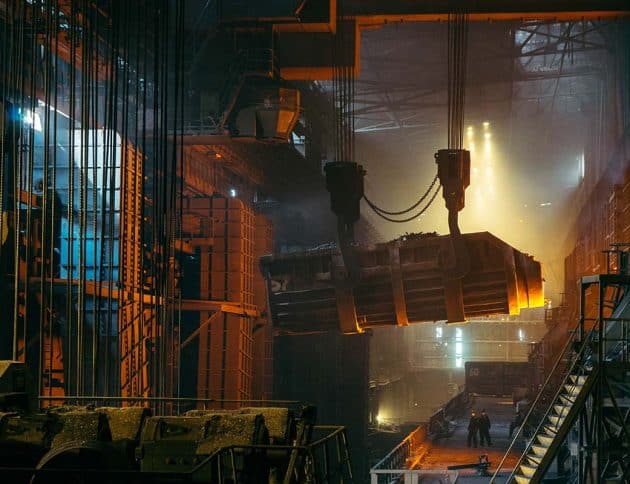 industrial warehouse with a large crane lifting a tank