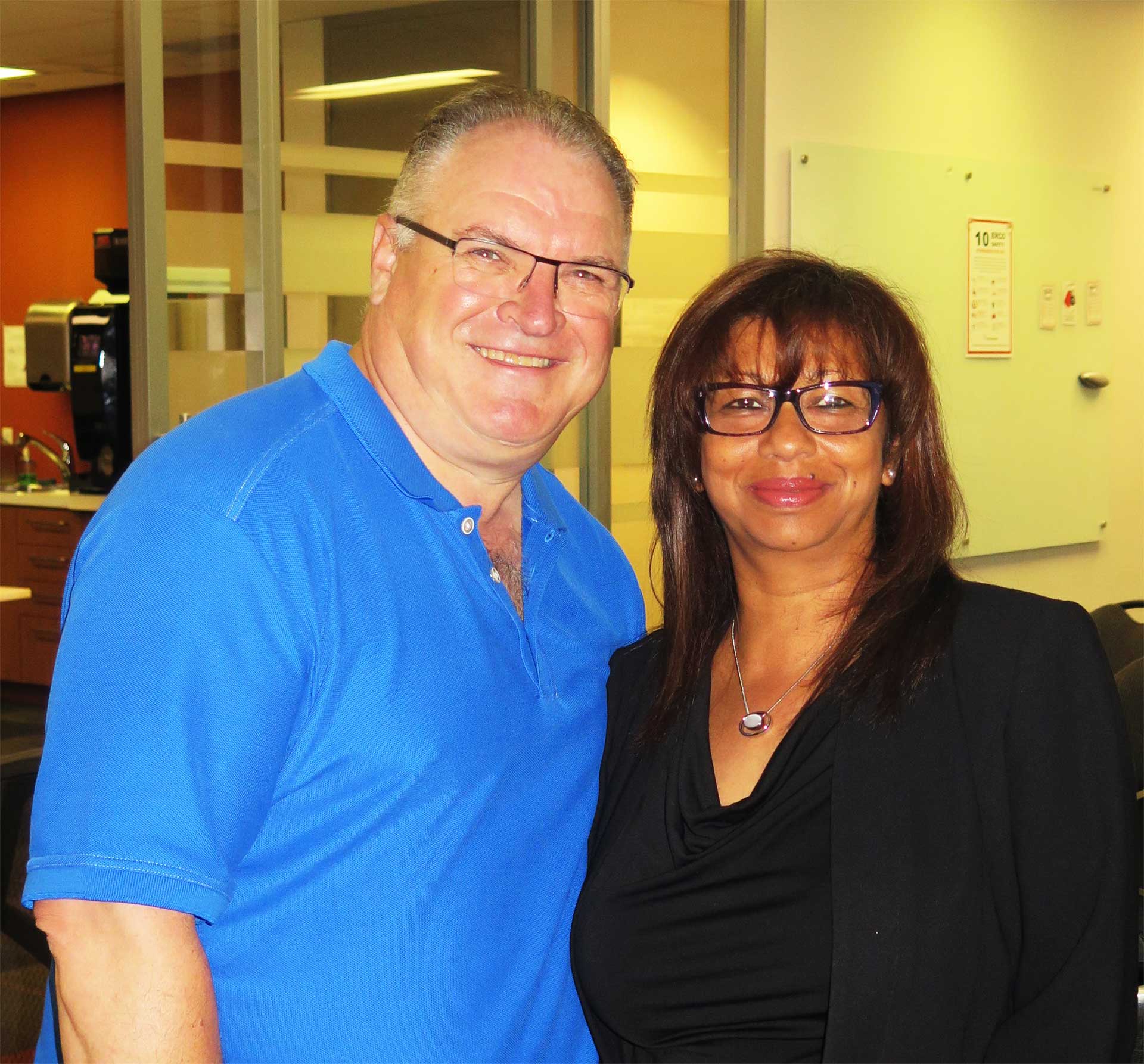 A female and male ERCO employee together smiling both wearing glasses