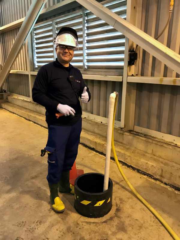 ERCO worker working while wearing a white hardhat and safety goggles giving the thumbs up gesture