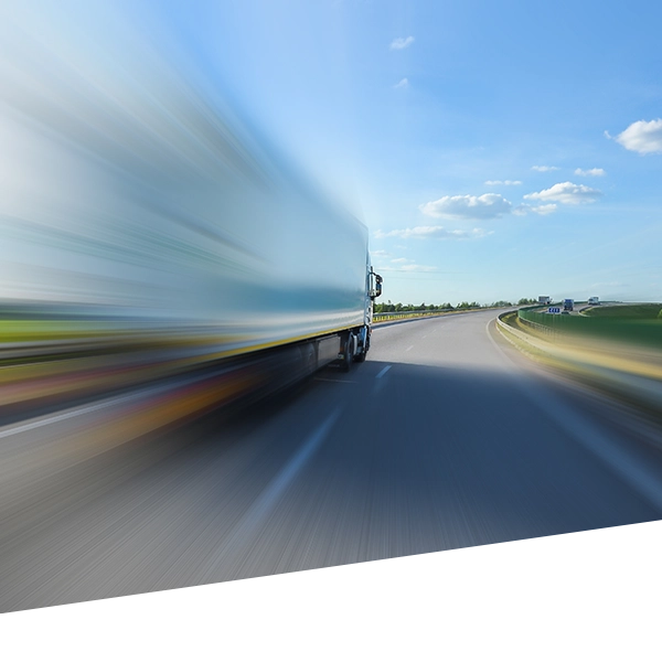 A transport truck speeds down an open road.